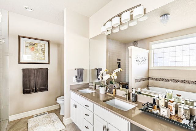 bathroom featuring toilet, double vanity, a sink, and visible vents