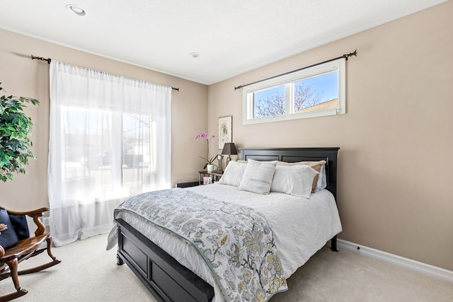 bedroom with light colored carpet and baseboards