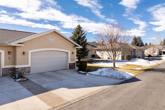 view of front of home featuring stone siding, an attached garage, driveway, and stucco siding