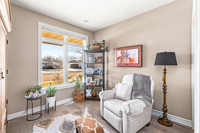 sitting room featuring visible vents, baseboards, and wood finished floors