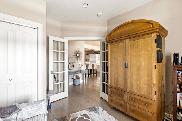 interior space with a closet, wood finished floors, and french doors