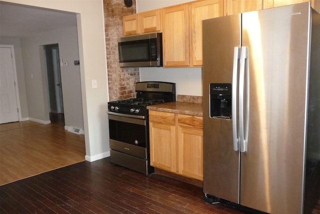 kitchen featuring baseboards, decorative backsplash, dark wood-style floors, appliances with stainless steel finishes, and light brown cabinets