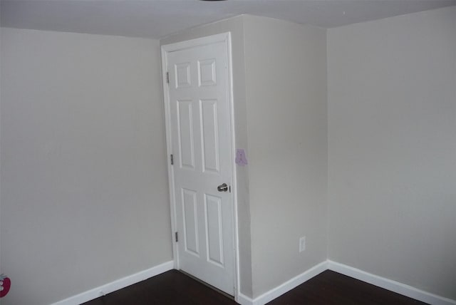 spare room with dark wood-style floors and baseboards