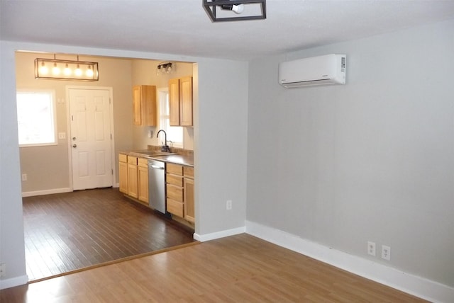 kitchen with dark wood finished floors, a wall mounted AC, a sink, dishwasher, and baseboards