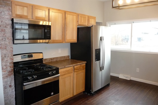 kitchen featuring stainless steel appliances, dark wood-style flooring, visible vents, baseboards, and light brown cabinetry