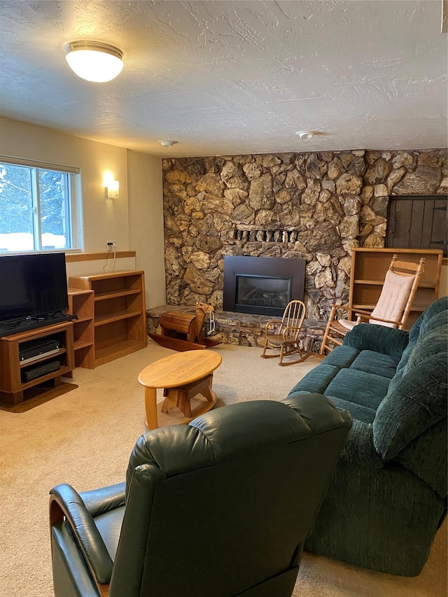 carpeted living room featuring a textured ceiling and a stone fireplace