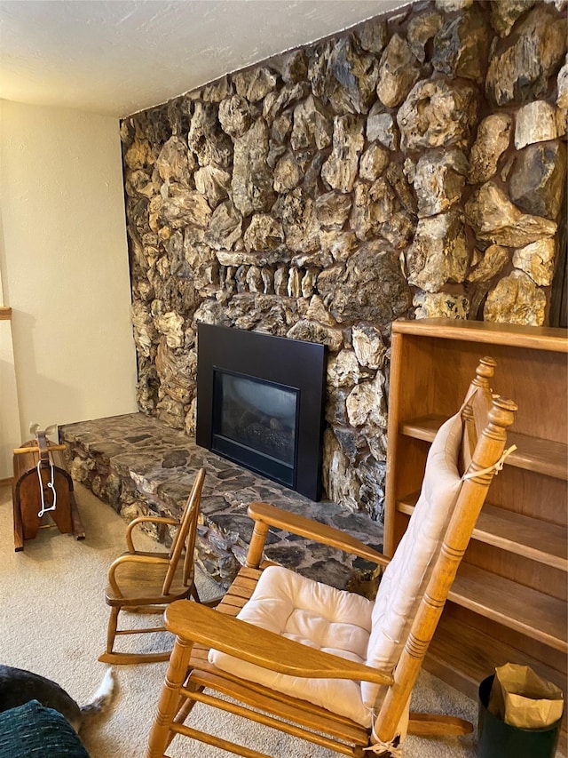 sitting room with a glass covered fireplace and carpet flooring