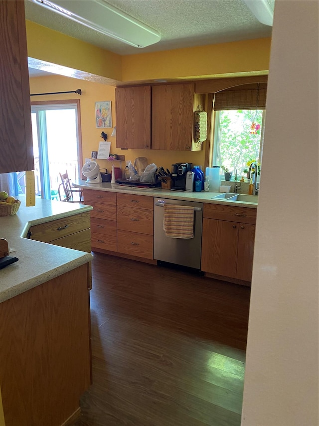 kitchen with a sink, plenty of natural light, light countertops, and stainless steel dishwasher