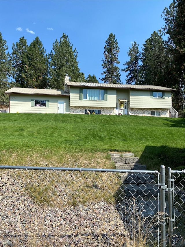 view of front of property featuring a chimney, fence, and a front lawn