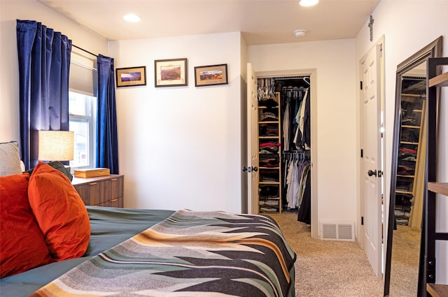 carpeted bedroom with a closet, a walk in closet, visible vents, and recessed lighting