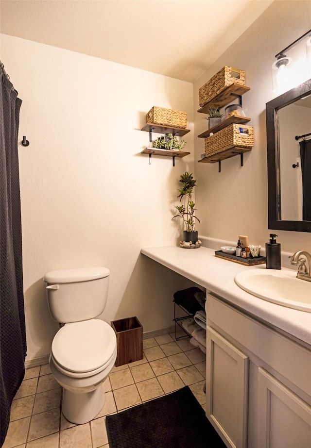 full bathroom featuring toilet, tile patterned flooring, vanity, and baseboards