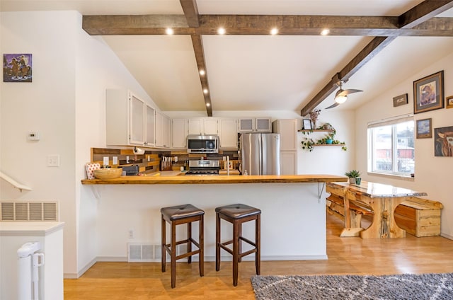1276 River St, Missoula, MT 59801 - kitchen with stainless steel appliances, light wood-style flooring, a peninsula, and light countertops