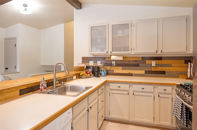 1276 River St, Missoula, MT 59801 - kitchen featuring stainless steel range with gas stovetop, light countertops, glass insert cabinets, light tile patterned floors, and a peninsula