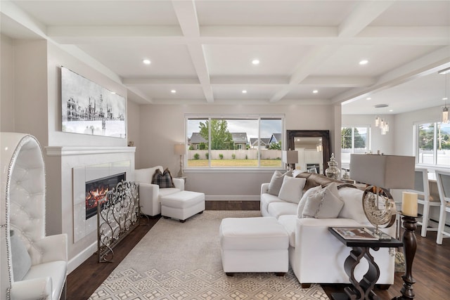 living area with beamed ceiling, a tiled fireplace, and wood finished floors