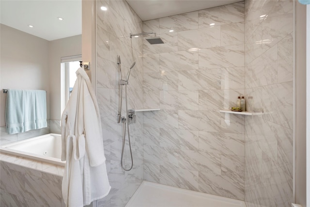 full bathroom with a jetted tub and tiled shower