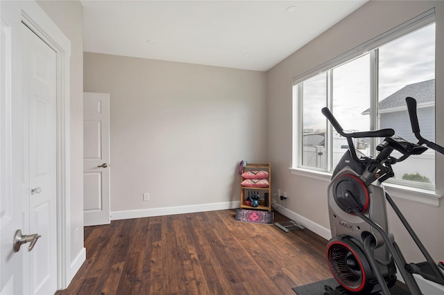 workout room featuring baseboards and wood finished floors