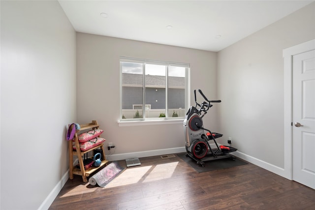 workout room featuring visible vents, baseboards, and wood finished floors