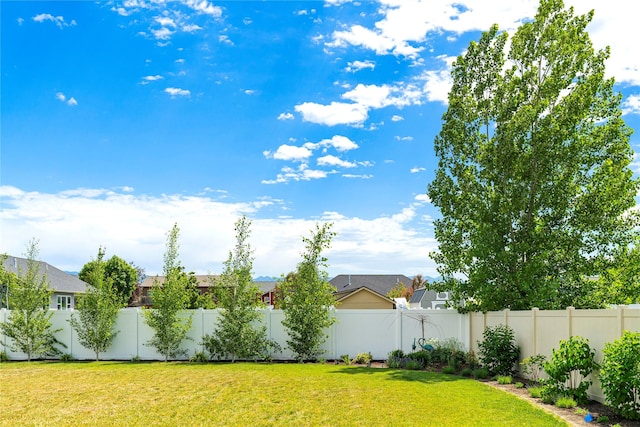 view of yard featuring a fenced backyard and a residential view