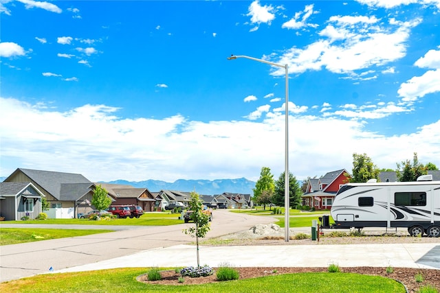 view of road featuring street lighting, a residential view, and a mountain view