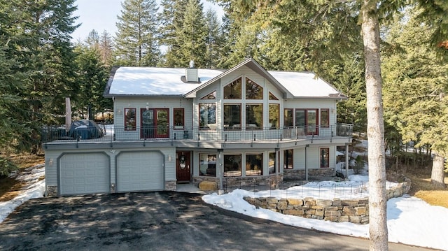 view of front of house with stone siding, driveway, and an attached garage