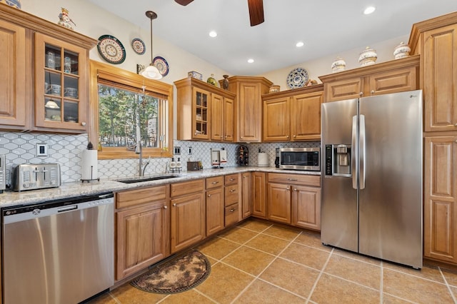 156 Wulff Ln, Lakeside, MT 59922 - kitchen featuring appliances with stainless steel finishes, a sink, a ceiling fan, light stone countertops, and backsplash