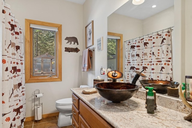156 Wulff Ln, Lakeside, MT 59922 - full bath with vanity, toilet, baseboards, tile patterned flooring, and a shower with curtain