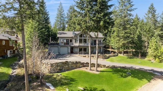 156 Wulff Ln, Lakeside, MT 59922 - back of house featuring driveway, a balcony, a lawn, a garage, and central AC unit