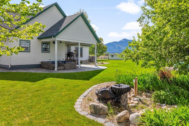 245 Olde Rd, Hamilton, MT 59840 - rear view of property with an outdoor living space, a ceiling fan, a patio, a mountain view, and a yard