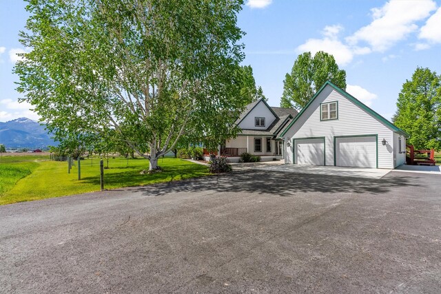 245 Olde Rd, Hamilton, MT 59840 - view of front of house with a garage, asphalt driveway, a front lawn, and a mountain view