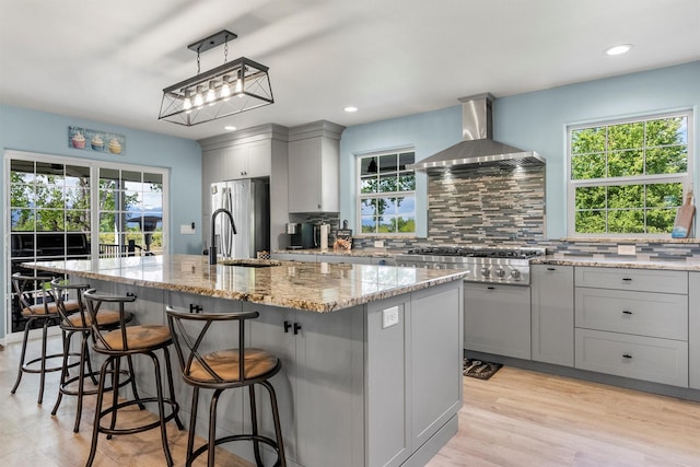 245 Olde Rd, Hamilton, MT 59840 - kitchen featuring stainless steel appliances, wall chimney exhaust hood, gray cabinetry, a sink, and decorative backsplash