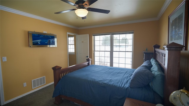 carpeted bedroom with a ceiling fan, baseboards, visible vents, and crown molding