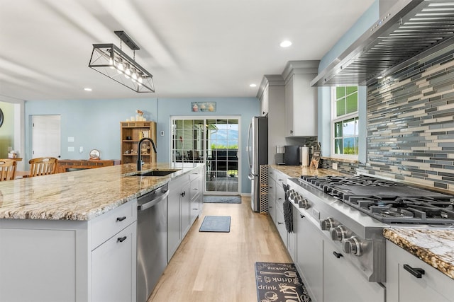 245 Olde Rd, Hamilton, MT 59840 - kitchen featuring appliances with stainless steel finishes, a sink, wall chimney range hood, light wood-style flooring, and tasteful backsplash
