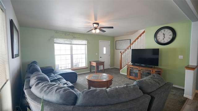 living room with a ceiling fan, stairway, and baseboards