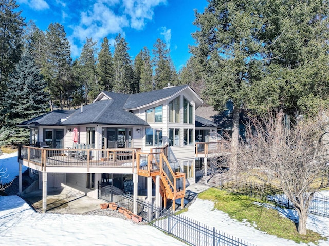 back of property with roof with shingles, a patio area, a carport, a fenced backyard, and stairs