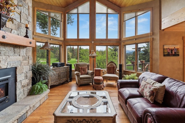 99 Golf Ter, Bigfork, MT 59911 - living area with wood-type flooring, high vaulted ceiling, wooden ceiling, and a fireplace
