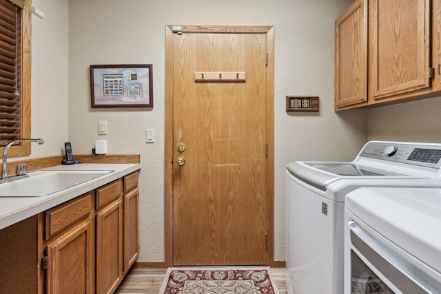99 Golf Ter, Bigfork, MT 59911 - laundry area featuring washer and dryer, cabinet space, a textured wall, and light wood finished floors