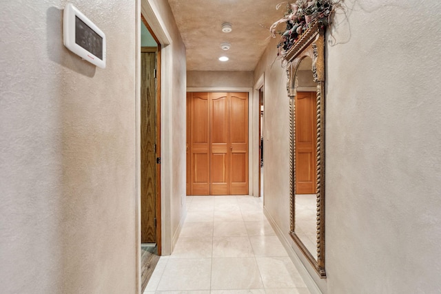 99 Golf Ter, Bigfork, MT 59911 - hallway featuring a textured wall, light tile patterned floors, and baseboards