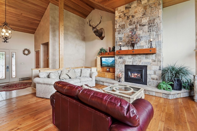 99 Golf Ter, Bigfork, MT 59911 - living room with wooden ceiling, a stone fireplace, wood finished floors, a baseboard heating unit, and a chandelier