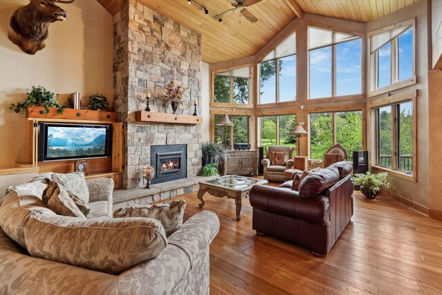 99 Golf Ter, Bigfork, MT 59911 - living room featuring wooden ceiling, wood-type flooring, high vaulted ceiling, a fireplace, and baseboards