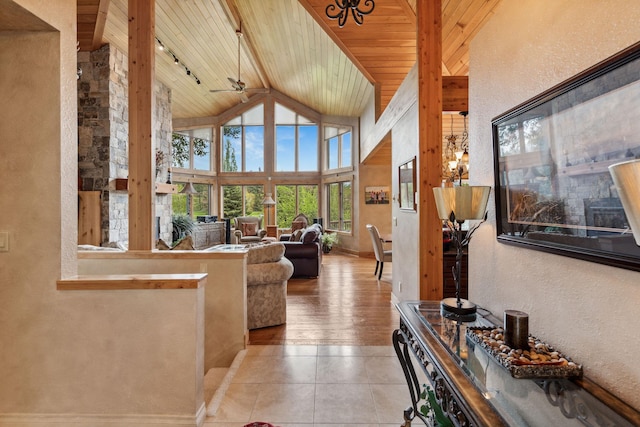 99 Golf Ter, Bigfork, MT 59911 - tiled living room with wooden ceiling, a textured wall, rail lighting, ceiling fan, and baseboards