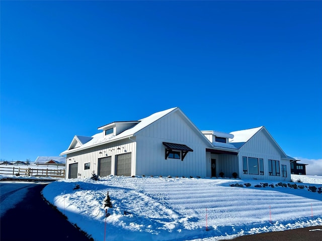 modern farmhouse style home with board and batten siding, fence, and a garage