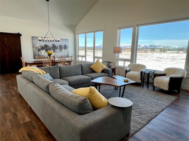 living room with high vaulted ceiling, a chandelier, and wood finished floors