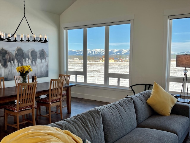 dining space with baseboards, dark wood finished floors, a chandelier, vaulted ceiling, and a mountain view