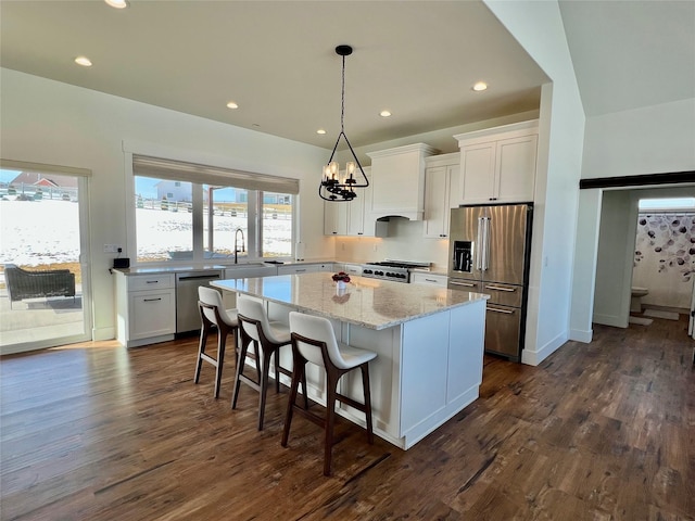 kitchen featuring white cabinets, appliances with stainless steel finishes, a center island, dark wood-style floors, and custom range hood