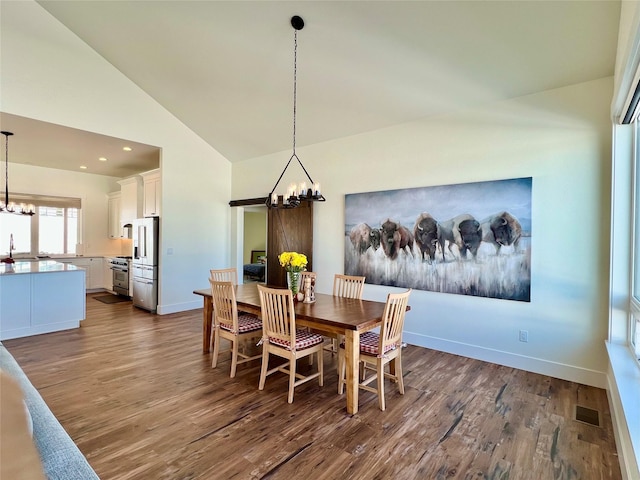 dining room with a chandelier, dark wood-style flooring, vaulted ceiling, and baseboards