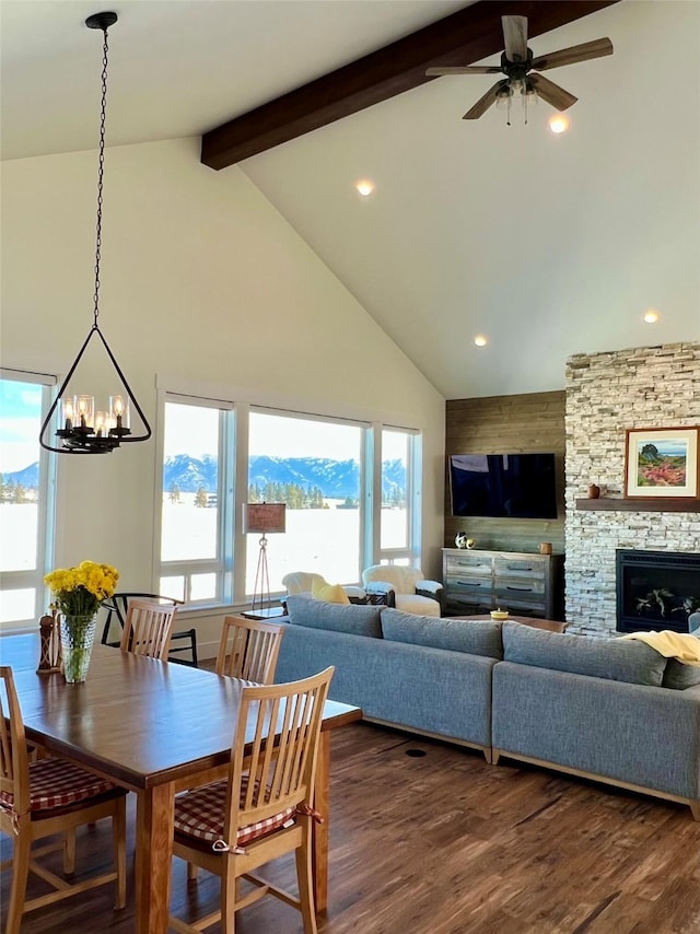 dining room with ceiling fan with notable chandelier, beamed ceiling, dark wood-style flooring, and high vaulted ceiling