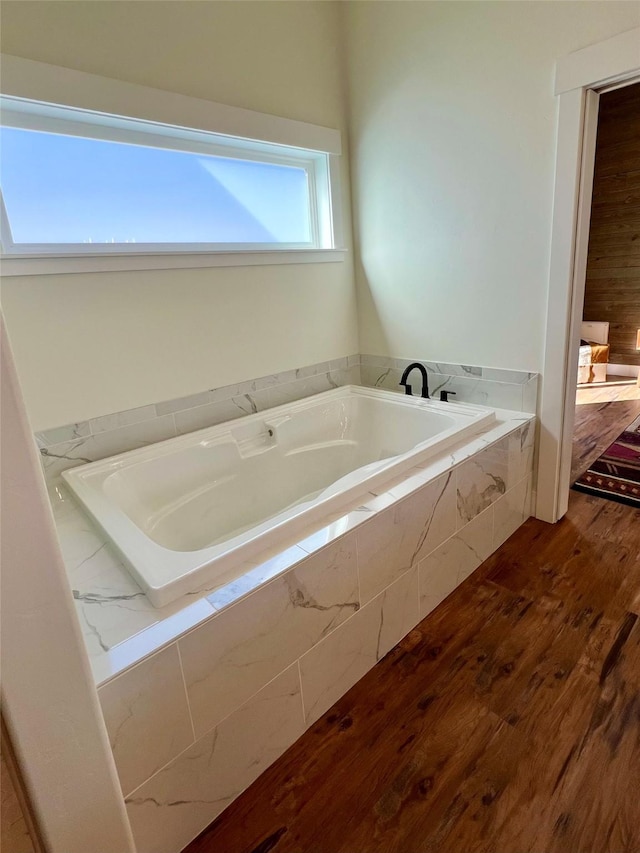 full bathroom featuring a garden tub and wood finished floors