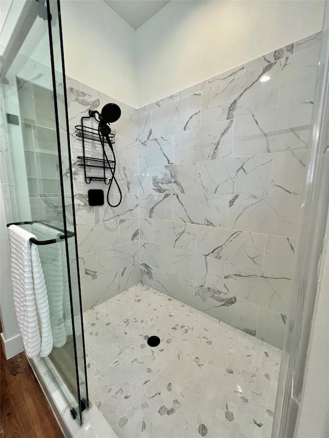 full bathroom with a shower stall and wood finished floors