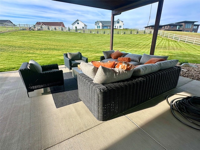 view of patio / terrace featuring a rural view, fence, and an outdoor living space