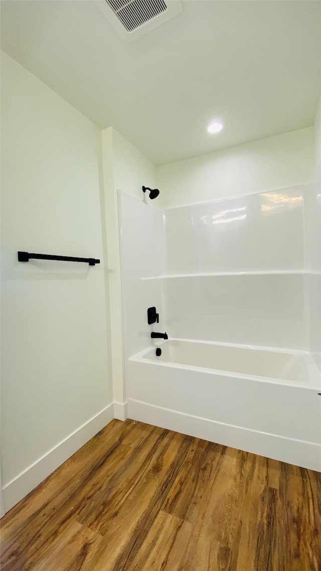 full bath with washtub / shower combination, visible vents, baseboards, and wood finished floors